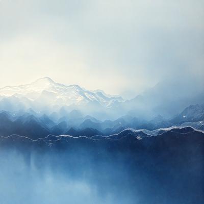 The primary subject of the image is a mountain range with a blue sky in the background. The setting is a mountainous landscape, and the visual style appears to be a photo. The dominant colors are blue and white, creating a serene and peaceful atmosphere.